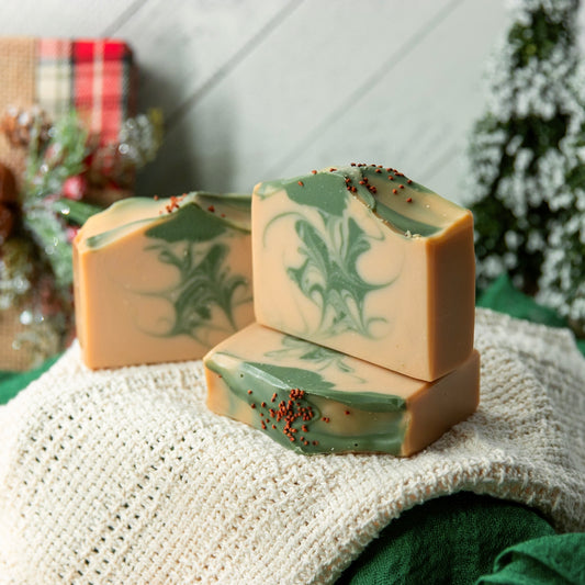 Three bars of soap with green and beige marbled pattern on a textured surface.