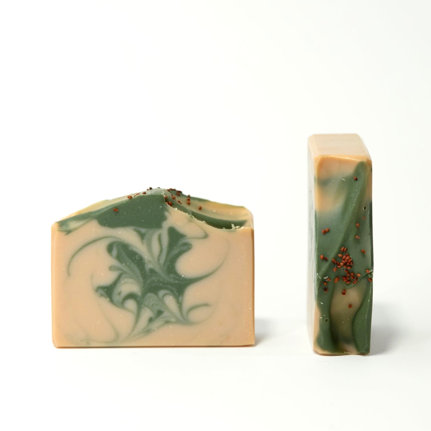 Two bars of soap with green and beige swirls on a white background